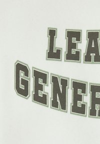 Vit tyg med fet, blockbokstäver. Texten "LEAD GENER" är i mörkgrön och omgiven av ljusgröna detaljer.