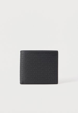 Cartera de cuero negro de doble pliegue con patrón repetido de texto "HUGO" en relieve, mostrada cerrada sobre un fondo blanco.