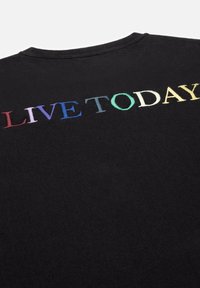 Zwarte T-shirt met multicolore geborduurde tekst "LEEF VANDAAG" op de achterkant, met een zachte textuur en een normale pasvorm.