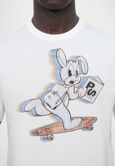 T-shirt en coton blanc avec un lapin cartoon coloré sur un skate, tenant un livre étiqueté "PS", avec des détails vifs et un design amusant.