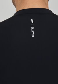 Zwart sportshirt met een gladde textuur, met een verticale witte "ELITE LAB" logo op de achterkant. Eenvoudig ontwerp en getailleerde vorm.