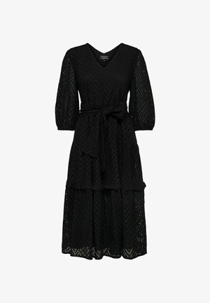 Robe en dentelle noire avec un décolleté en V, des manches trois-quarts et une taille ceinturée. Présente une jupe à volants avec un motif en chevrons.