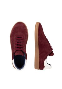 Baskets en suede bordeaux avec semelles en caoutchouc marron, accents de talon blancs, et six lacets violets. Présente des détails perforés sur les côtés.