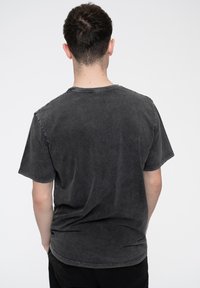 Gray, short-sleeve T-shirt with a relaxed fit. Features a crew neckline and distressed texture. The fabric appears soft and slightly faded.