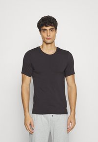 T-shirt nera a maniche corte realizzata in tessuto morbido, con scollo rotondo e design slim fit. Stile semplice e versatile.