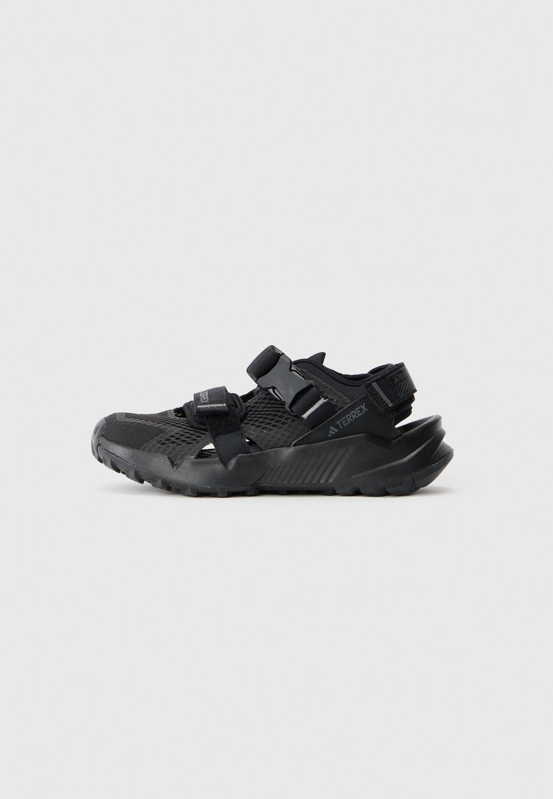 Sorte udendørs sandaler med mesh-overdel, justerbare stropper, tekstureret sål og forstærket tåkap. Letvægtsdesign for forbedret greb.