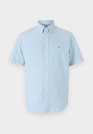 Kurzarmpf shirt in Hellblau aus Baumwolle. Es hat eine weiche Textur, einen abgerundeten Saum und ein kleines Logo auf der linken Brust.