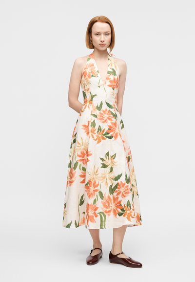 Φλοράλ φόρεμα με halter λαιμόκοψη, με κρεμ φόντο και πορτοκαλί και κίτρινα λουλούδια, εφαρμοστό μπούστο και φούστα με φούντα.