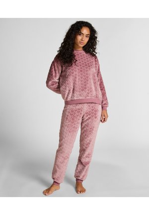Ensemble de loungewear rose doux avec un motif texturé et matelassé. Le haut a une coupe ample et des poignets côtelés ; le bas a des chevilles élastiquées.