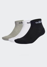 Tre paia di calzini alla caviglia in grigio, bianco e nero. Ognuno presenta un polsino a coste con il dettaglio del logo "adidas" in un colore contrastante.