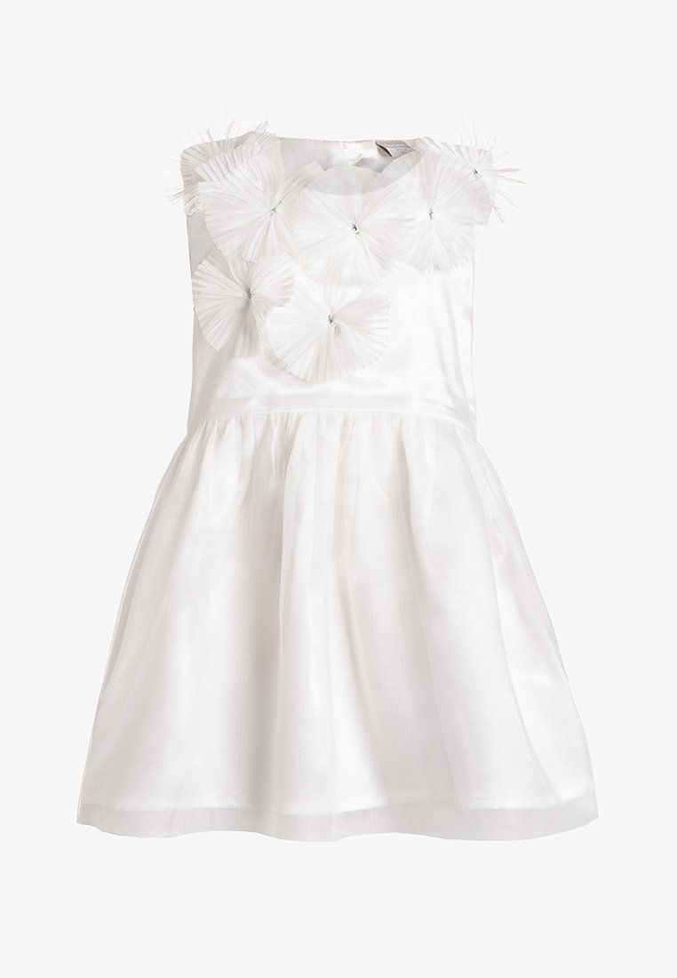 Robe blanche sans manches avec corsage ajusté, jupe évasée et appliques florales en tulle superposées décoratives sur le haut de la poitrine et les épaules.