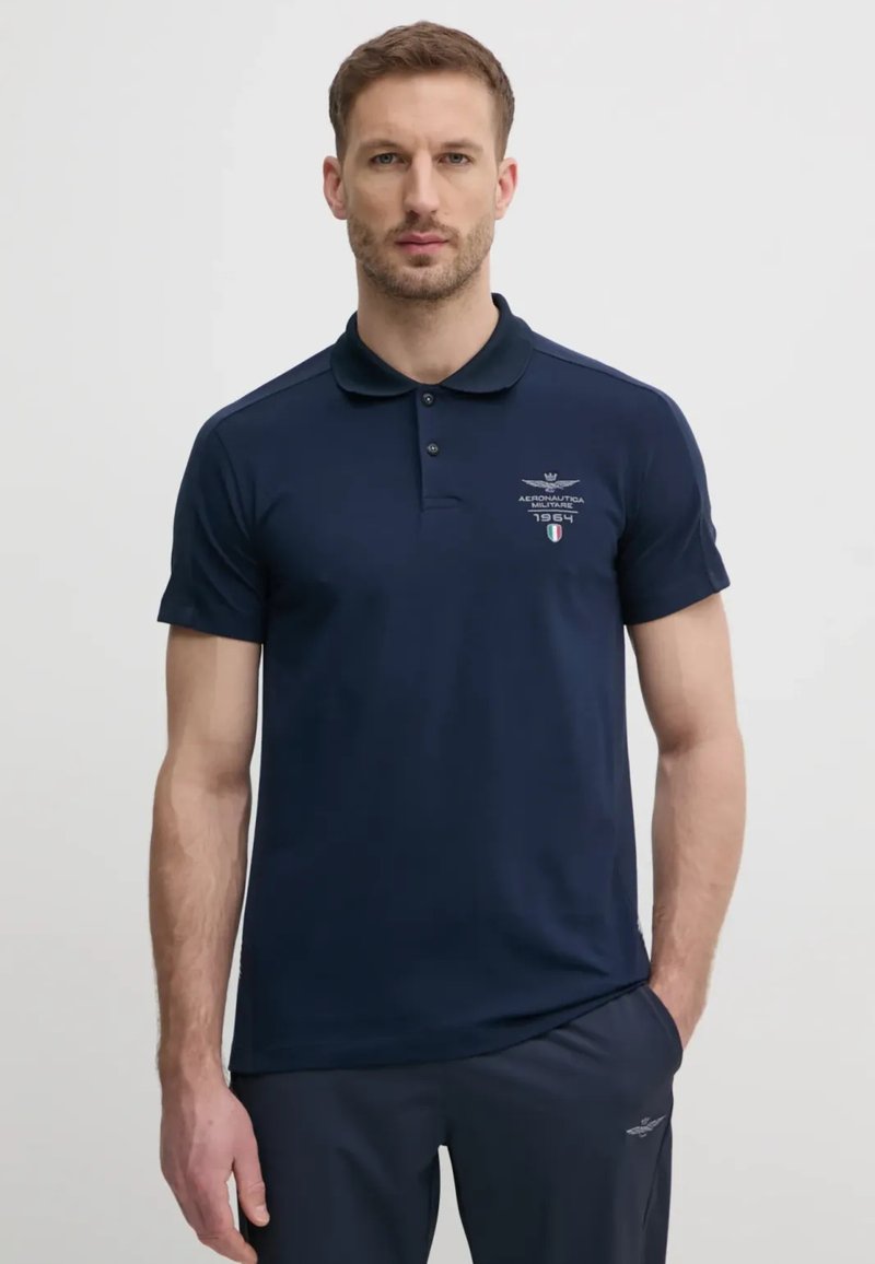 Polo shirt blu navy con colletto classico, maniche corte e dettagli del logo ricamati. Realizzato in un tessuto morbido, presenta una vestibilità slim.