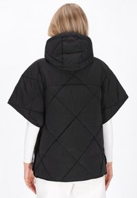 Sort quiltet pufferjakke med hætte, der har en bred, asymmetrisk pasform og et diamantformet quiltet mønster.