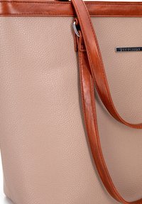 Beige leren tote bag met een gestructureerde afwerking, aangevuld met een gladde bruine accentriem en zilveren hardware. Voorzien van logodetail.