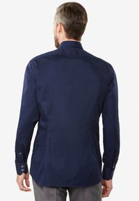 Navy blue shirt with long sleeves, a standard collar, and buttoned cuffs. Smooth texture, fitted design with a slight taper at the waist.