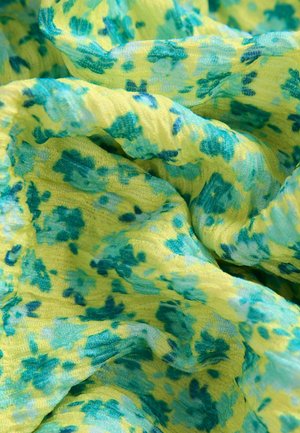 Tessuto con motivo floreale caratterizzato da una miscela di tonalità gialle e verdi. Materiale leggero e testurizzato con una caduta morbida e accenti irregolari blu.