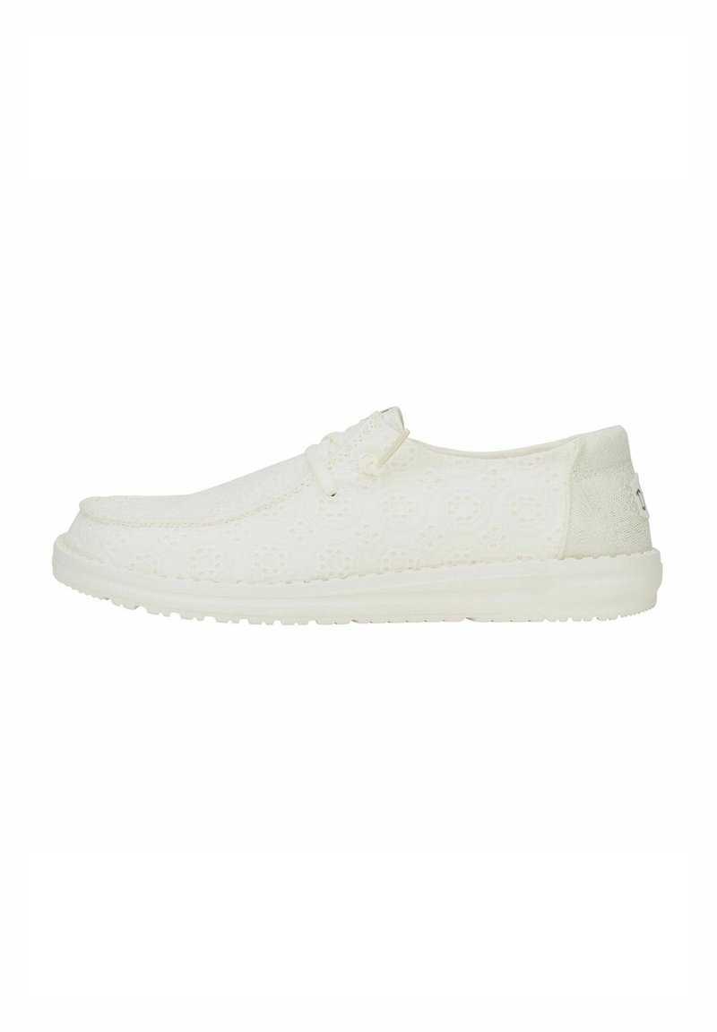 Scarpe casual bianche realizzate in tessuto texturizzato, con punta arrotondata, lacci elastici e una suola morbida e flessibile. Design minimalista, leggero.