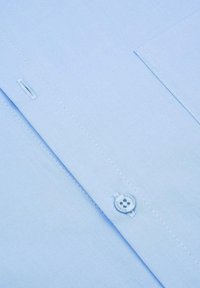 Jasnoniebieska koszula o prostym kroju, zapinana na guziki, z kieszenią na piersi ozdobioną subtelnymi przeszyciami. Gładka tekstura materiału.