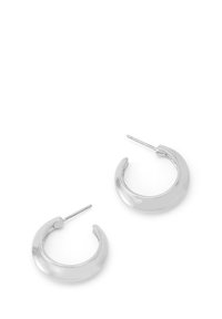 Une paire de boucles d'oreilles créoles épaisses en argent brillant avec fermoirs à tige sur fond blanc.