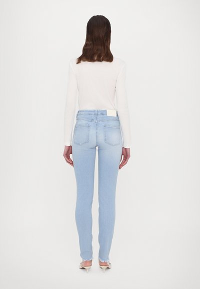 Lyseblå skinny jeans med slitt kant, høy midje og baklommer. M materialet har en glatt tekstur med moderat stretch.