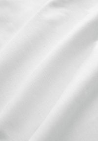 Tissu blanc à la texture lisse et à la brillance subtile, présenté en douces ondulations. Le matériau semble léger et étroitement tissé.