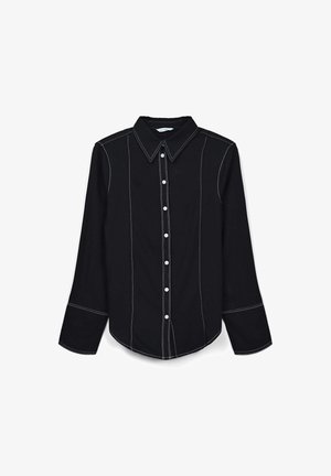Black long-sleeve shirt featuring white contrast stitching, a classic collar, buttoned front, and rounded hemline.