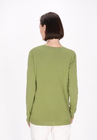 Maglione verde a maniche lunghe in un materiale morbido e leggero, con scollo rotondo e polsini a coste, mostrato da dietro.