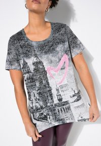 Camiseta gris de manga corta con un estampado de paisaje urbano, que presenta un diseño de corazón rosa. Fabricada con una tela suave y de corte relajado.