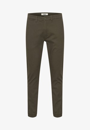 Alkšnio žalios spalvos taperingo modelio kelnės, pagamintos iš medvilnės mišinio, su sagčių užtrauktuku, šoninėmis kišenėmis ir elastingais rankogaliais, užtikrinančiais prigludusį stilių.