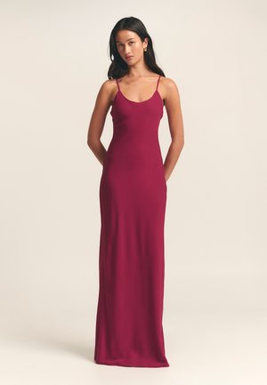 Mauve spaghetti strap evening dress, form-fitting, floor-length, featuring a smooth, sleek texture with a simple, minimalistic design.