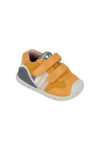 Zapatillas de niño de ante y cuero amarillo con dos correas de velcro, detalles en gris y blanco, puntera redondeada y suela de goma texturizada.