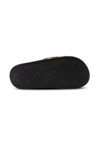 Black rubber shoe sole featuring a textured pattern with circular grips, a rectangle logo at the center, and rounded edges.