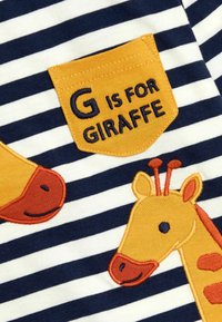Gestreifter Stoff in Marineblau und Weiß mit einer gelben Tasche. Bestickter Text "G steht für GIRAFFE" neben Giraffenmotiven in Orange und Gelb.