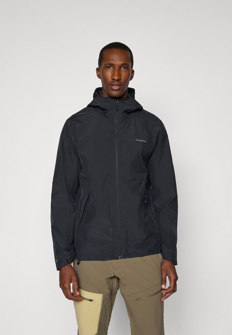 Schwarze wasserdichte Jacke mit einer gerafften Kapuze, Frontreißverschluss und Seitentaschen. Leichtes Material mit einer glatten Textur.