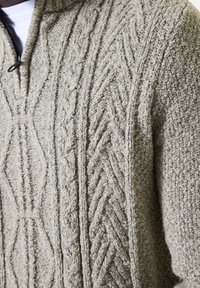 Lichtgrijze gebreide trui met een textuurpatroon, kwart rits sluiting en een capuchon; bevat kabels en diamantsteek ontwerpen.
