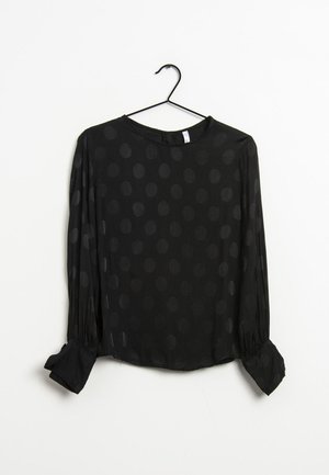 Blusa nera a maniche lunghe con motivo a pois, scollatura rotonda e polsini con bottoni. Realizzata in tessuto trasparente con una consistenza liscia.