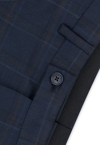 Granatowa kraciasta tkanina z brązowymi akcentami, z czarnym guzikiem i przeszywanymi detalami. Gładka tekstura i wyraźna struktura.