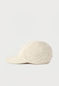 Μπεζ καπέλο με κυρτό γείσο, κατασκευασμένο από ελαφρύ, υφασμάτινο υλικό με υφές, που διαθέτει διάτρητα πάνελ για αερισμό και διακριτική λεπτομέρεια με λογότυπο.