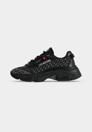 Baskets Moschino noires avec tige en mesh imprimé, semelle épaisse, lacets et petit détail cœur rouge près du logo sur le côté.