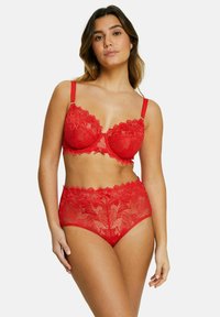 Ensemble de soutien-gorge en dentelle rouge et slip taille haute, avec des motifs floraux, des bords festonnés et des bretelles ajustables avec des accents en métal doré.