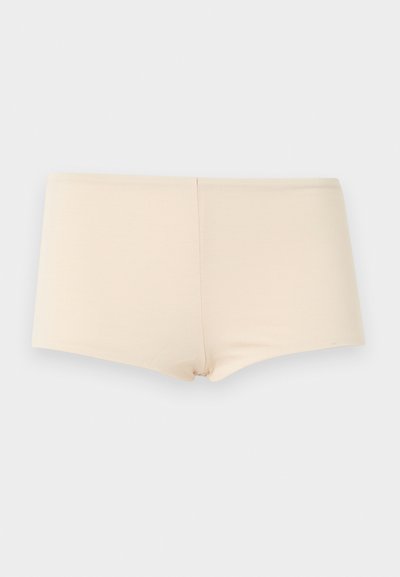 Μπεζ αδιάκοπο εσώρουχο τύπου boyshort με λεία υφή, απλωμένο επίπεδα σε ανοιχτό γκρι φόντο.