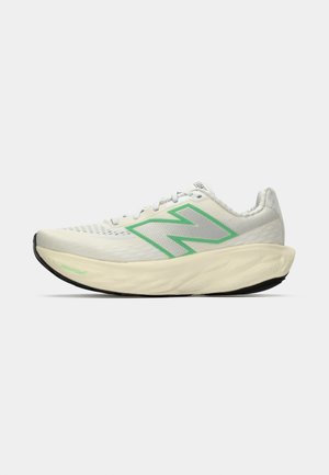 Baskets de course blanches et jaune pâle avec un logo New Balance vert, semelle rembourrée marquée "Fresh Foam" et tige en mesh pour la respirabilité.