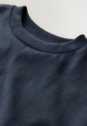 T-shirt en coton bleu marine avec un col ras du cou côtelé. Texture lisse et design simple, sans motifs ni accents visibles.