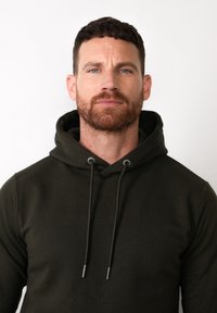 Felpa verde oliva con cappuccio e coulisse, realizzata in morbido tessuto. Presenta una tasca a marsupio e polsini a coste, caratterizzando un design elegante e minimalista.