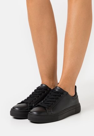 Black leather sneakers with lace-up design, rubber sole, and textured accents on the heel. Smooth finish and rounded toe shape.