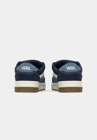 Tamno plave i svijetloplave suede tenisice s bijelim naglascima i VANS logotipom na poleđini. Gumeni potplat s teksturiranim uzorkom. Niski dizajn.