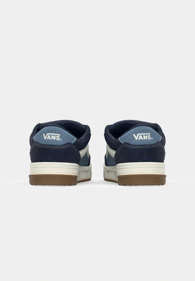 Baskets en daim bleu marine et bleu clair avec des accents blancs et le logo VANS à l'arrière. Semelle en caoutchouc avec un motif texturé. Design basse.