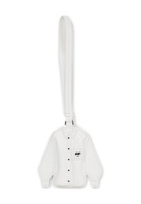 Biały skórzany brelok w kształcie koszuli z długim rękawem, z czarnymi guzikami i kieszonką zdobioną rysunkiem kota w stylu kreskówkowym. Gładka tekstura.