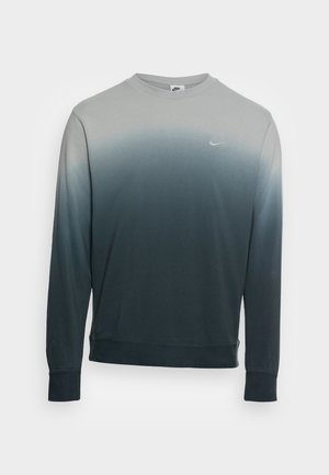Langärmeliges Nike Sweatshirt mit Rundhalsausschnitt, das einen Farbverlauf von Hellgrau oben zu Dunkelgrau unten zeigt und ein kleines Logo auf der Brust trägt.