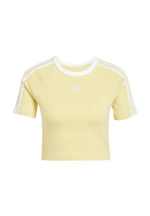 Camiseta amarilla recortada hecha de tela suave, con un cuello de canalé blanco y tres rayas blancas en cada hombro, con logo en el pecho.